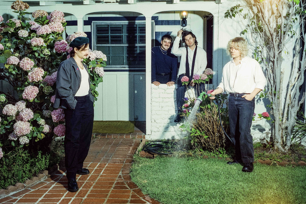 Australian indie rock band Vacations posing outside a house with hydrangeas, photographed by Pooneh Ghana
